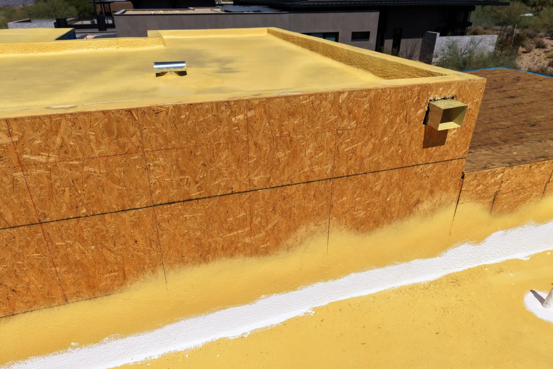 Spray foam roof applied over parapet walls on a desert new build