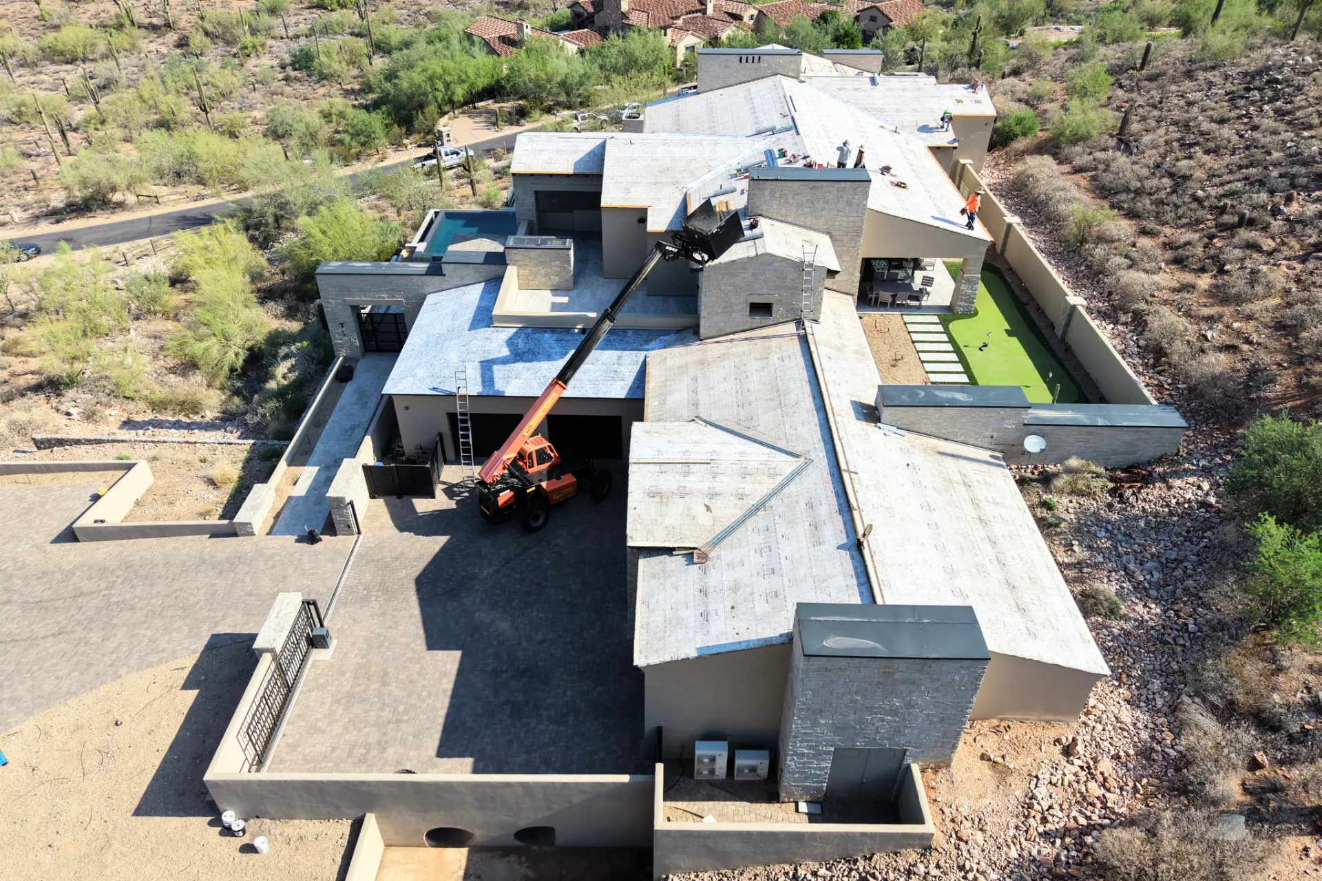 Crew installing underlayment on a large luxury desert home