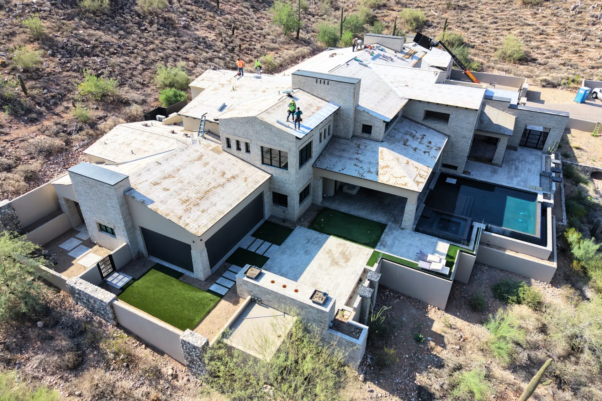 Roofing crew working on a stone clad Arizona luxury home