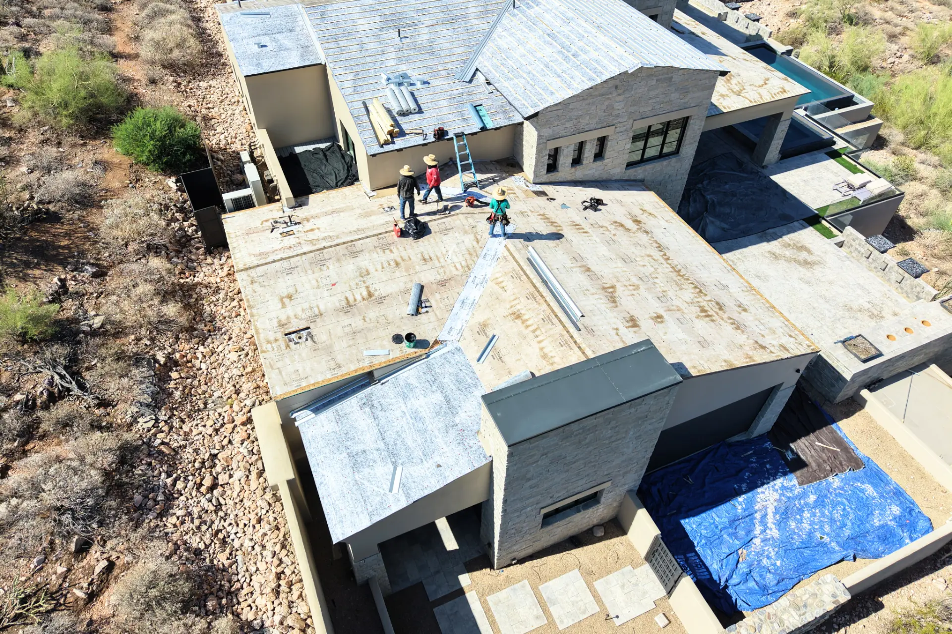Crew laying underlayment on a stone clad luxury home in Scottsdale